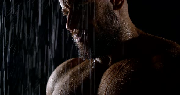 The Face of a Brutal Bearded Muscular Male Bodybuilder Close-up on a Black Background, He Is in the