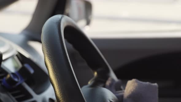 Unrecognizable Man in Gloves Wiping Car Wheel