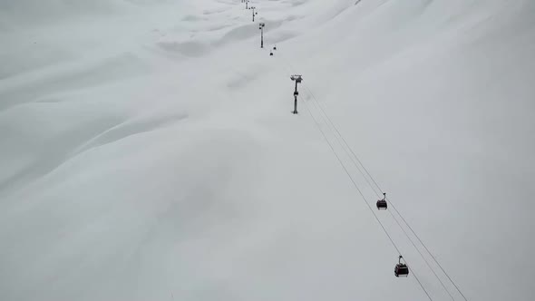 Cableway Lifting Above Snowy Hills.