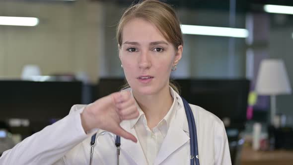 Portrait of Disappointed Young Female Doctor Doing Thumbs Down