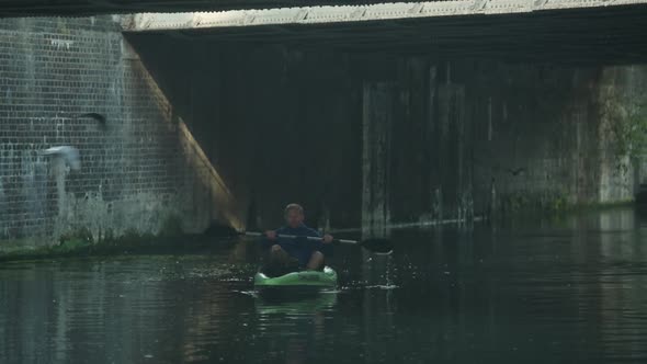 A man on a kayaking adventure in a urban setting