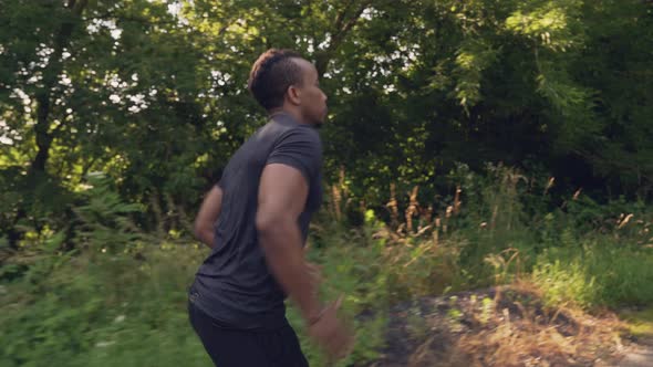 Muscular African Guy Running in Forest During Morning Time
