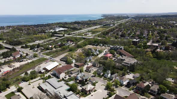 Aerial flyover Grimsby City with traffic on highway and blue Lake Ontario in background. Beautiful s