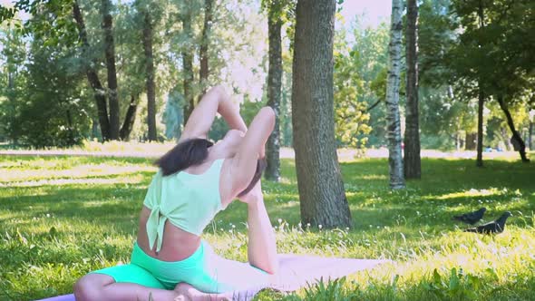Beautiful Brunette Woman Sportswear Trains Yoga Asana Green Juicy Grass Purple Mat Barefoot Doing