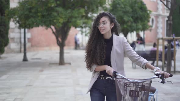 Lovely Moroccan Girl Strolling At The Park With A Bicycle