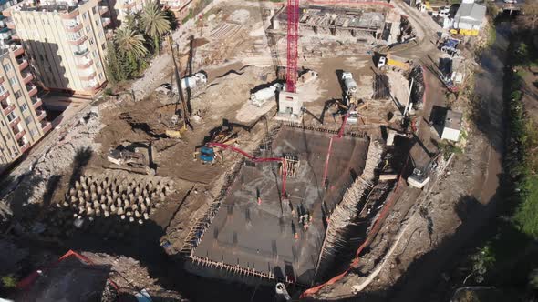 Workers working on construction site, filling foundation with cement.