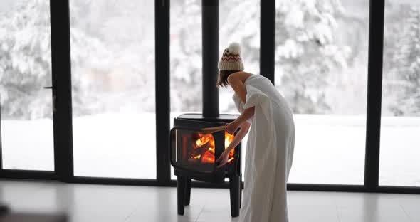 Woman at Home with Burning Fireplace During Wintertime on Nature