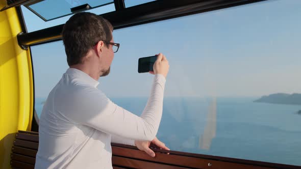Tourist is Photographing Sea View From Cable Car
