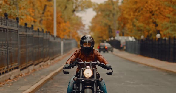 Tough Guy Motorcyclist Rides Around the City in the Fall