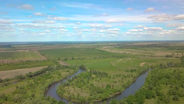 Flight Over Green Meadow, Forest and River in Spring