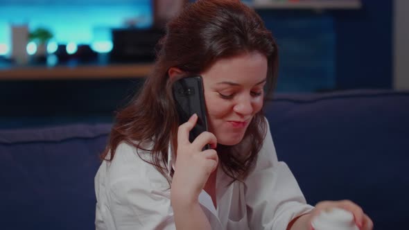 Young Woman Drinking Beverage While Talking on Smartphone