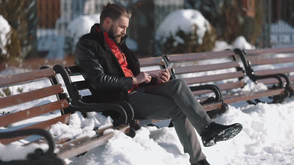 Man Using Smartphone Outdoors During Winter Time