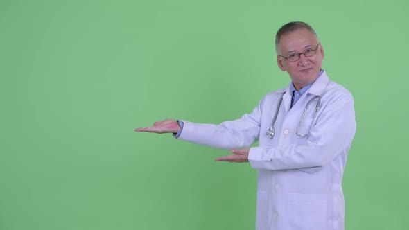 Happy Mature Japanese Man Doctor Snapping Fingers and Giving Thumbs Up