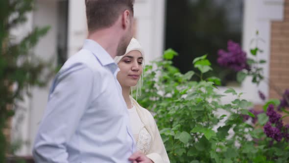 Confident Middle Eastern Bride in Hijab Leaving with Caucasian Groom