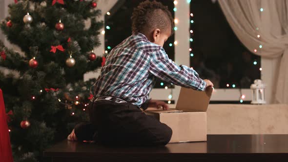 Kid Unpacking Gift on Table.