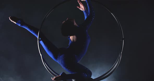 Graceful Woman is Doing Aerial Gymnastics in the Hoop Spinning