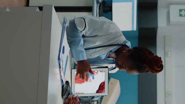 Vertical Video Doctor Showing Tablet with Heart Figure for Cardiology Checkup