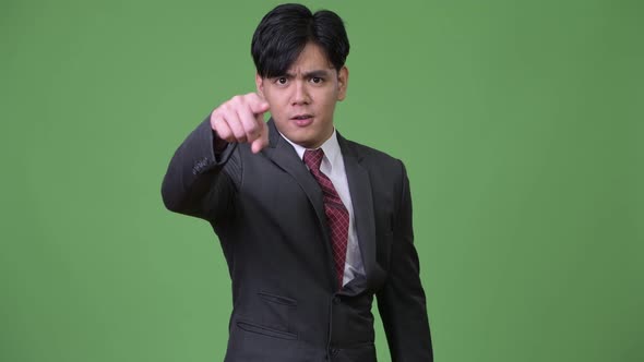 Young Angry Asian Businessman Pointing To Camera