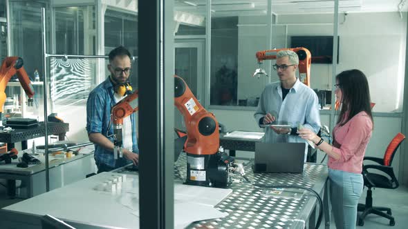 Young Scientists Are Testing a Robotic Device. Young Engineers Working in Innovative Laboratory.