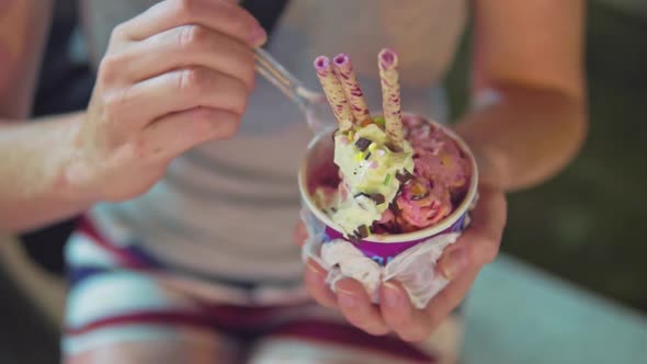 Fruit ice cream in a cup with a nut, straws and chocolate crumb