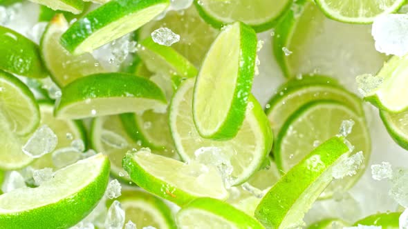 Super Slow Motion Shot of Flying Fresh Lime Slices and Crushed Ice Towards Camera at 1000Fps