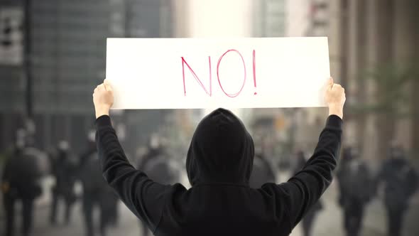 Unknown Protester Holds a Placard with NO Text