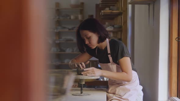 Young female potter working in her studio