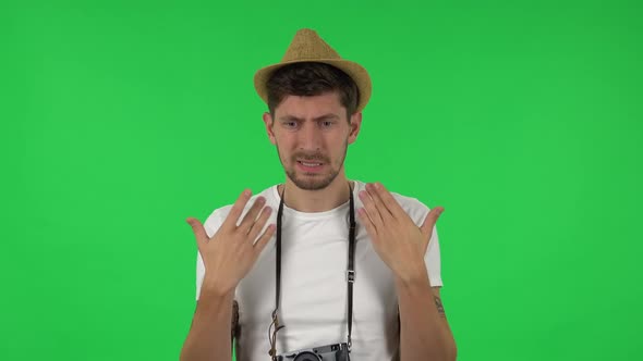 Portrait of Confident Guy Is Cooling Herself By His Hand, Suffering From High Temperature Weather