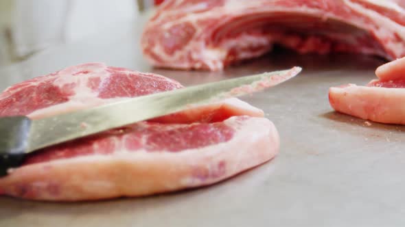 Close-up of knife on sliced red meat