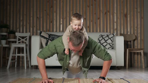 Father Pushesup with Little Son on Back and Poses Looking