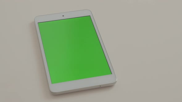 Tablet PC  with green screen display on white reflective surface  4K 3840X2160 UHD footage - Greensc