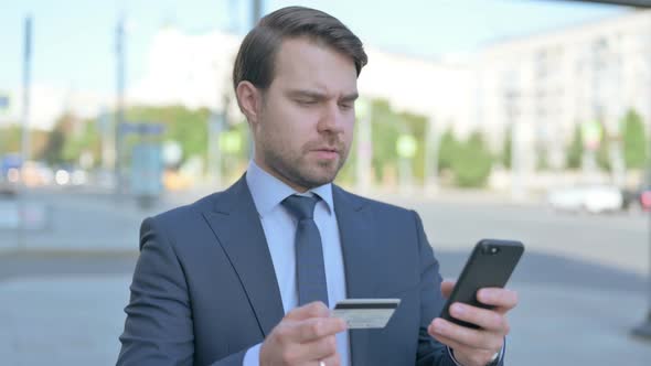 Excited Businessman Shopping Online via Smartphone, Outdoor