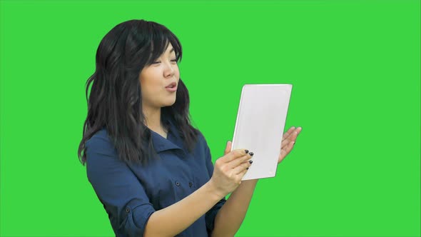 Asian Business Lady Chatting Using a Tablet on a Green Screen Chroma Key