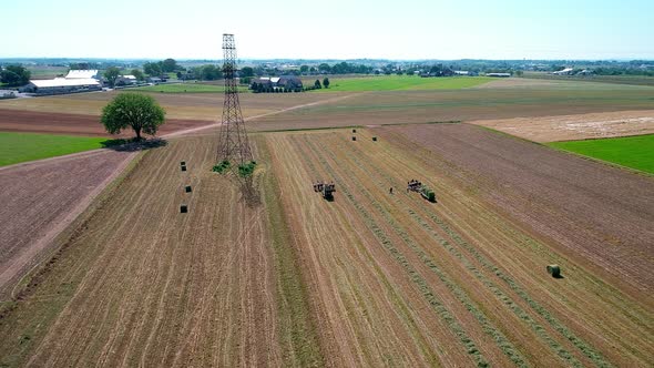 Amish Farm Worker Harvesting the Fields with old and New Equipment