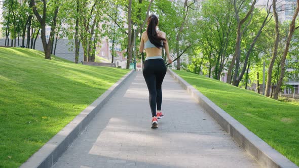 Woman Jogging in Park in the Morning