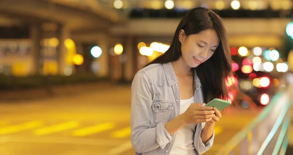 Woman Looking at Mobile Phone in The Evening 