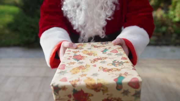 POV Santa Clause Giving Present to Unrecognizable Person Standing on Backyard Porch