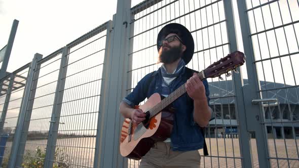 Young Guy Walks in the Sunset Light and Plays the Guitar. Freedom Concept