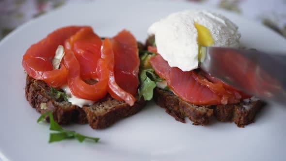 Chef Cuts Piece of Sandwich with Greens and Salmon