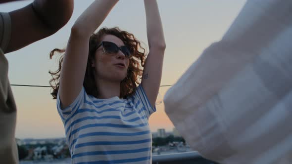 Caucasian friends dancing at the party in top of the roof. Shot with RED helium camera in 8K.