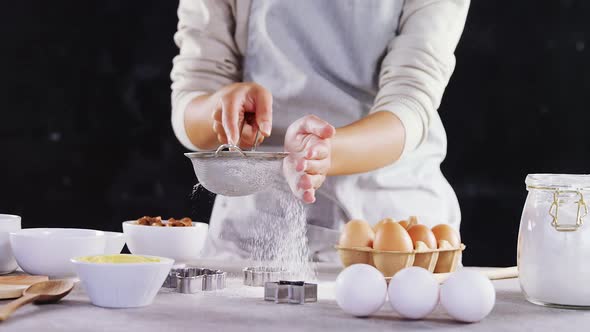 Woman staining flour in sieve