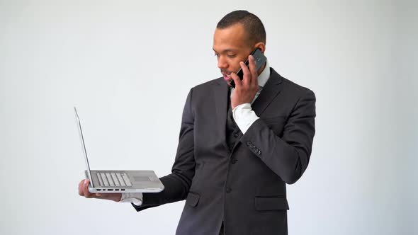 Professional African-american Business Man Holding Laptop Computer and Talking on the Phone