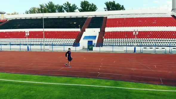 A Man with a Bionic Leg Is Walking Along the Stadium