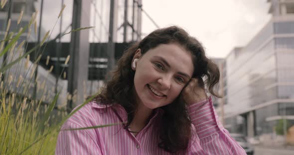 Portrait of young attractive teenager in urban background listening to music