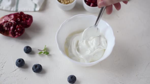 Mixing Greek yogurt in the white ceramic bowl