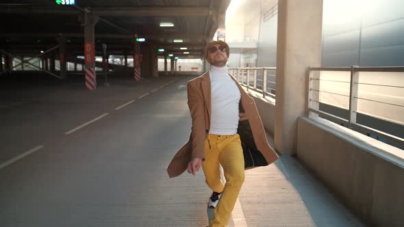 Cheerful and Happy Young Man with Beard Actively Dancing While Walking Down the Street on Sunset