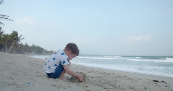Carefree Baby Boy Builds a House From Sand Child Plays By the Sea