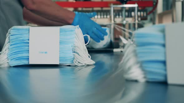 Coronavirus Protection Mask Production Line. Stacks of Face Masks Being Wrapped in Polyethylene