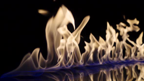 On a Black Reflective Background the Fire Ignites and Burns in Slow Motion