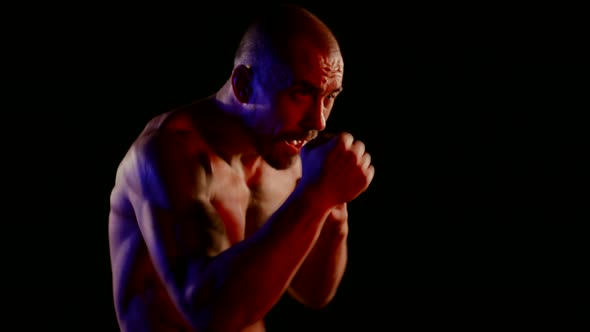 Aggressive Kickboxer is Training in Night Portrait of Tired Fighter in Darkness